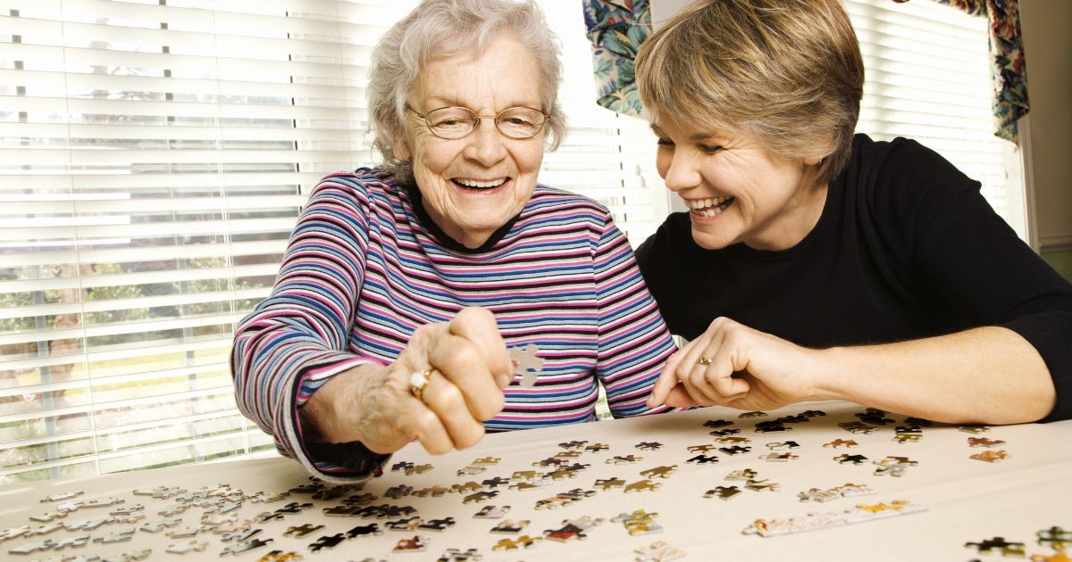 caregiver playing puzzles with elderly