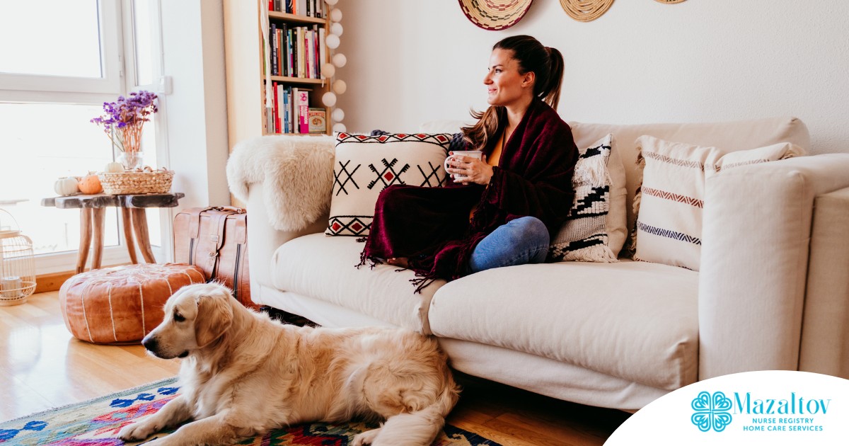 A woman relaxes with her dog while sipping on tea, representing how self-care can combat caregiver stress.