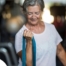 An older woman uses a resistance band to exercise, representing how staying active can help older adults keep their blood pressure in a healthy range.