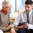 An older man talks with a doctor representing the effective communication that family caregivers should endeavor to have.