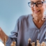 An older woman plays chess, an activity that can help older adults stay sharp.